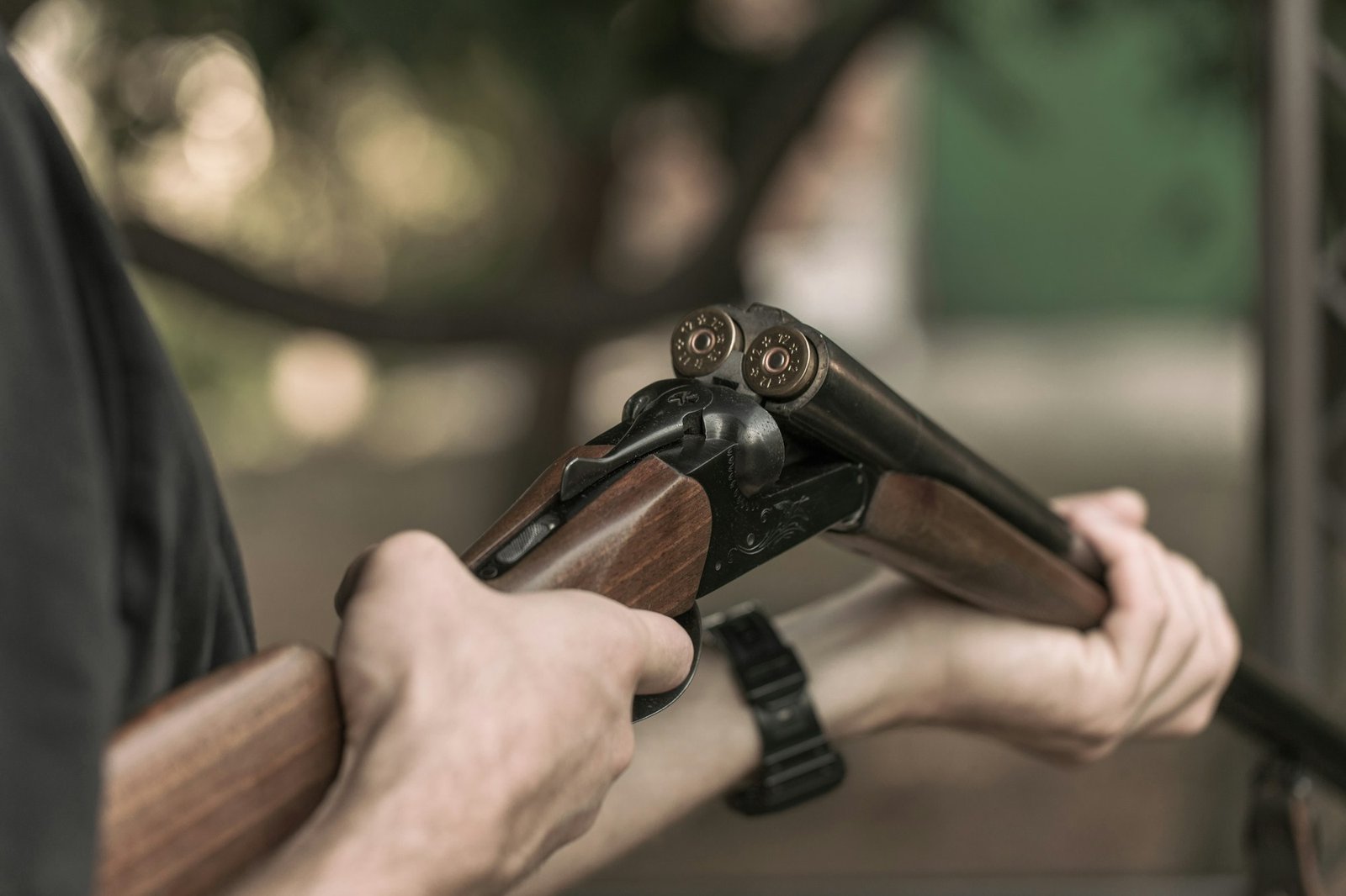 Man charging double-barreled hunting rifle closeup